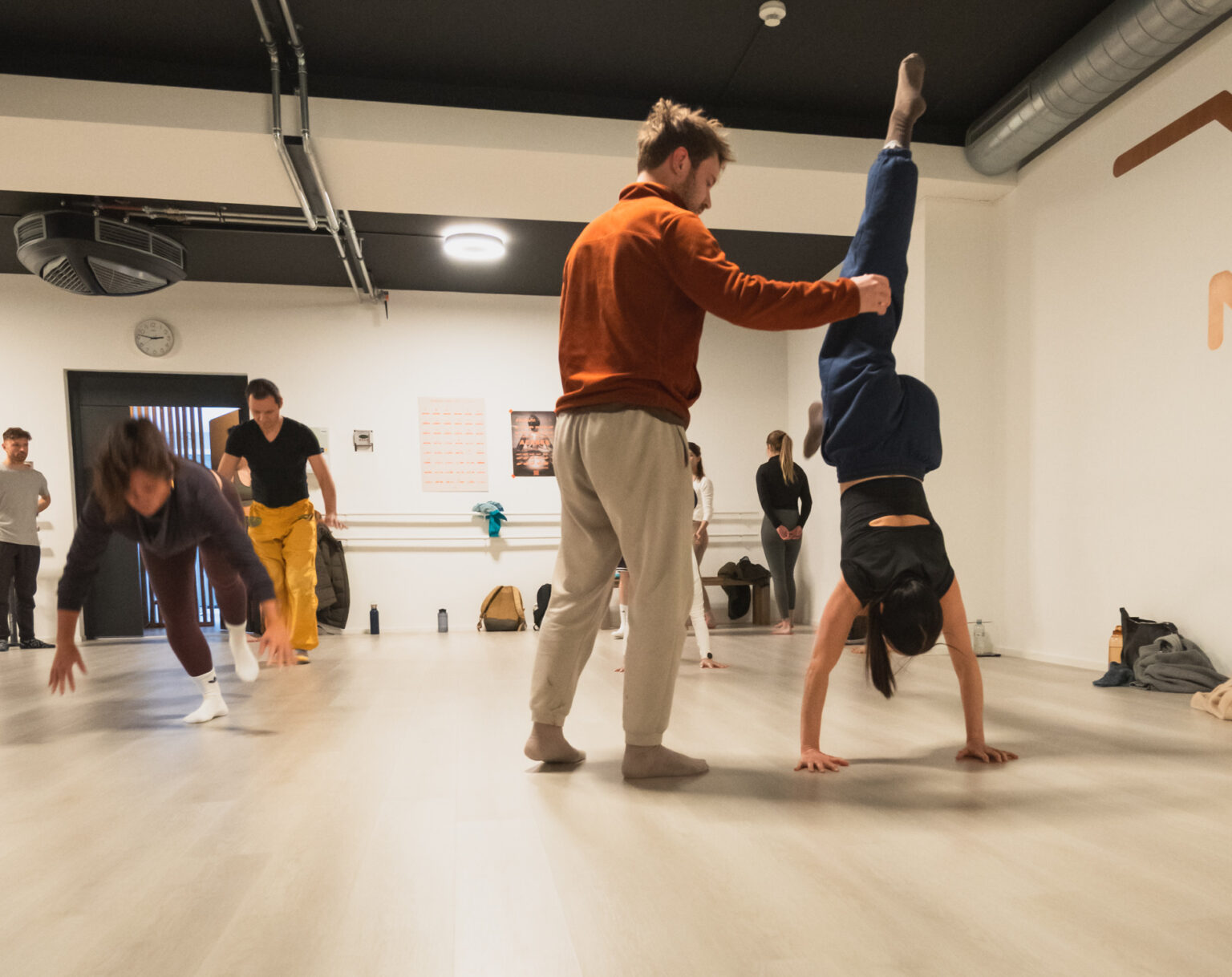 Marius spots a participant in a handstand while the group trains