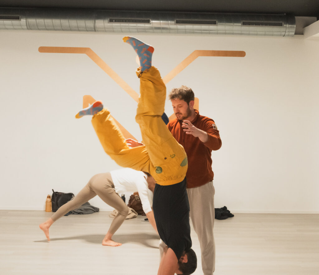 Marius spots a participant kicking up into a handstand